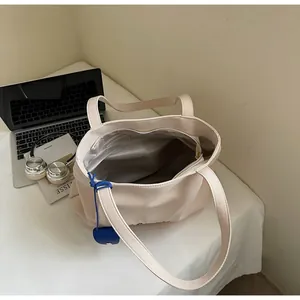Interior view of off-white canvas tote bag showing silver lining and zipper pocket