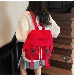 Detail showing red nylon backpack with flap closure and adjustable buckles in lifestyle setting