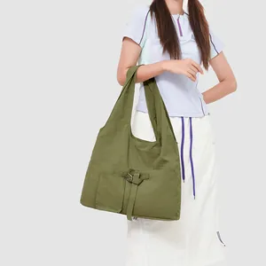 Detail van olijfgroene tote tas met utility klepzakken en een brede schouderband