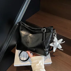 Minimalist black glossy shoulder bag with silver star charm and metallic logo brand plate
