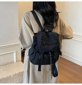 Fashionable black nylon backpack for travel and yoga shown from a back perspective