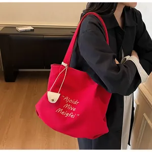 Detail of red canvas tote bag showing white text and durable fabric texture