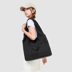 Detail van zwarte canvas shopper met functioneel gespvak en brede comfortabele riem