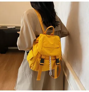 Detailed view of yellow waterproof nylon backpack featuring a flap and buckle closure