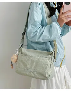 Detail der hellgrünen Nylon-Umhängetasche mit Gubblo-Stickerei und Bärenanhänger