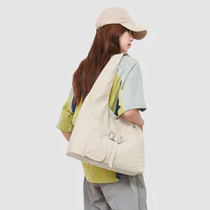 Minimalistische beige schoudertas met gespzak getoond op een vrouwelijk model