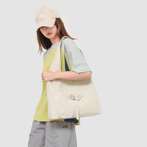 Detail van beige canvas draagtas met functionele zak met gesp voor dagelijks woon-werk