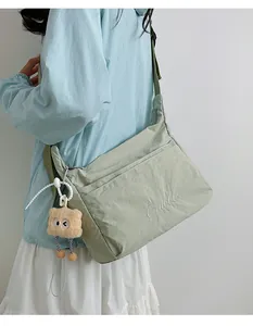 Nahaufnahme hellgrüne Nylon-Umhängetasche mit Gubblo-Stickerei und Toast-Anhänger