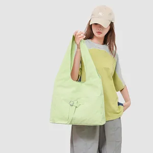 Detail van de lichtgroene tote bag met voorvak met klep en verstelbare metalen gesp