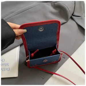 Mini navy denim crossbody bag with red trim and cherry embroidery for women