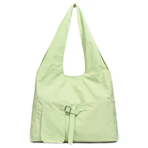 Minimalistische mintgroene schoudertas met grote zakken en gestructureerde nylon afwerking