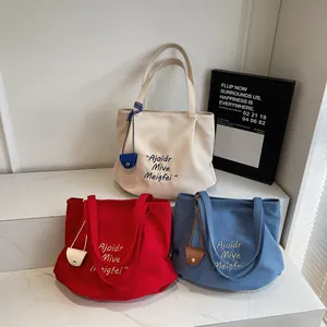 Three minimalist large-capacity tote bags in white, red, and blue with leather charms