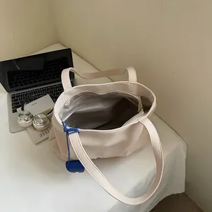 Minimalist beige canvas tote bag with large capacity for daily commute or travel