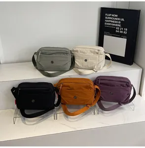 Detailed view of lightweight nylon crossbody bags in five colors with circular logo