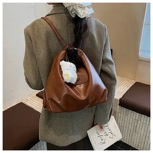 Vue arrière d'un sac à dos vintage en similicuir marron avec un charm ours mignon