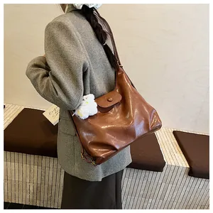 Gros plan du sac cabas rétro marron avec un joli accessoire en peluche blanche