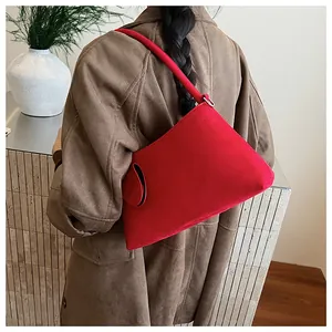 Detail showing the red suede material and metal ring buckle of the minimalist underarm bag