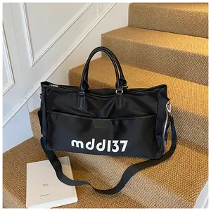 Detail of black large capacity travel bag with leather handles and mddl37 print