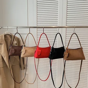 Minimalist faux suede shoulder bags in five colors hanging on a metal rack