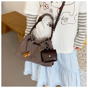 Detail of coffee canvas bucket bag with mini leather pouch and peanut pin accessory