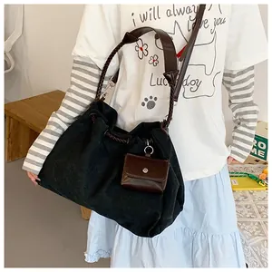 Detail of black canvas tote bag with brown woven strap and matching coin purse