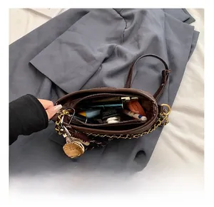 Internal view showing compartments of brown quilted bucket bag with makeup items