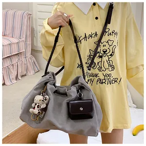 Close-up of grey canvas tote bag featuring woven straps and a plush leopard doll charm