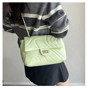 Détail du sac bandoulière matelassé vert menthe avec fermoir tournant en métal sur mannequin