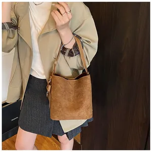 Close-up of retro brown bucket bag featuring matte texture and adjustable strap detail