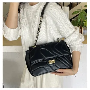 Vue détaillée du sac à bandoulière en cuir noir matelassé avec chaîne dorée et fermoir