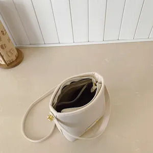 Borsa a secchiello color crema con interno multistrato e dettagli zip dorati