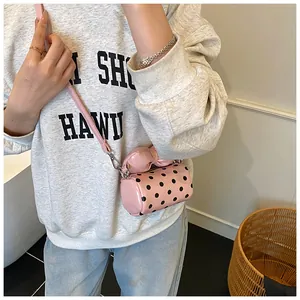 Detailed view of pink polka dot mini bag with bow accent and silver metal hardware strap