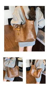 Close-up of large dark brown leather tote bag with unique wooden bead tassel detail
