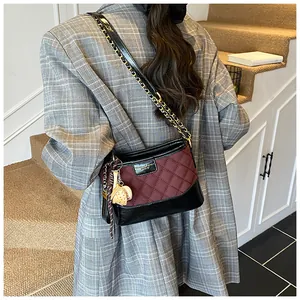 Quilted burgundy and black bucket bag featuring baseball charms and chain strap