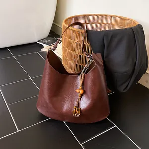 Vintage καφέ δερμάτινη τσάντα bucket με boho φούντα από ξύλινες χάντρες και στυλ