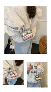 Detail view of silver mini crossbody bag with red polka dots and a large bow design