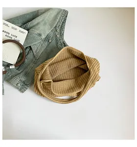Close-up of khaki knitted tote bag texture with striped pattern and spacious interior
