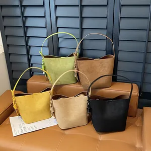 Matte leather bucket bags in five colors with top handle and metal lock detail
