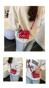 Detail view of mini red polka dot crossbody bag with a large decorative bow and strap