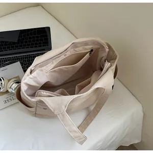 Vue de dessus montrant les compartiments intérieurs et la poche zippée du sac en nylon beige
