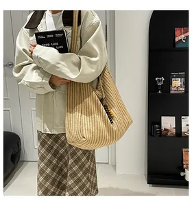 Macro view of textured beige striped knit tote bag with decorative wooden beads