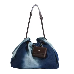 Large denim tote bag with gradient wash and brown braided shoulder strap for women