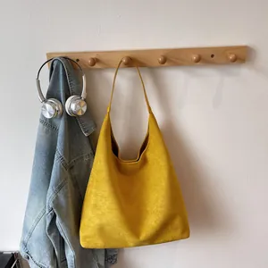 Close-up of mustard yellow suede tote bag hanging with high-quality matte finish