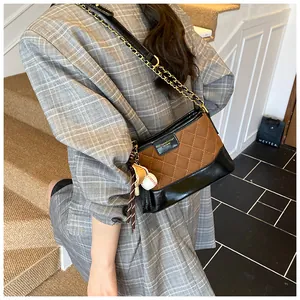 Detailed quilted bucket bag with chain strap and sporty glove charm accessory
