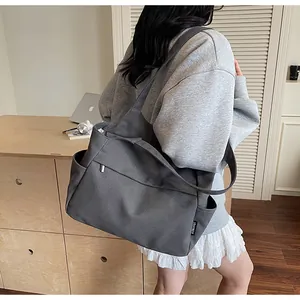 Vue détaillée du grand sac cabas en nylon gris foncé avec poches et bandoulières doubles