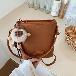 Borsa a secchiello in pelle martellata marrone con ciondolo a orso e logo oro