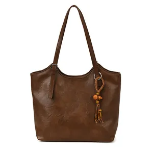 Minimalist vintage large brown tote bag with woven tassel charm and adjustable shoulder strap