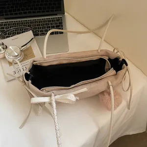 Elegante beige Wildleder-Tragetasche mit Schleife und Plüschanhänger im Lifestyle-Design