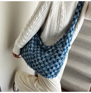 Detail der blau-weißen Schachbrett-Jeans-Tasche mit trendigen, ausgefransten Kanten