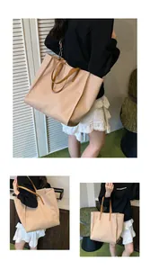 Detail view of large beige tote bag with slim brown handles and waterproof texture
